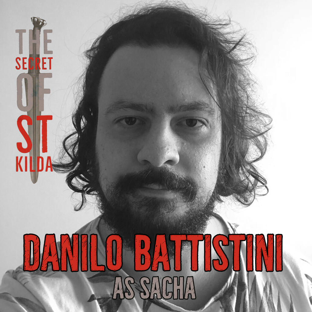 Danila Battistini as Sacha. Serious black and white headshot of white man with mid-length curly dark hair and full beard