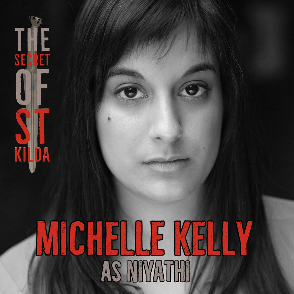 Michelle Kelly as Niyathi. Serious black and white headshot of brown-skinned woman with long black hair